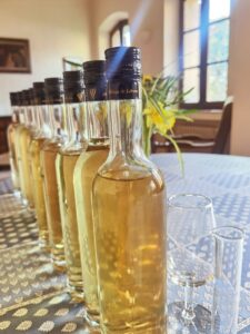 Bouteilles de liqueur de l'Abbaye de Lérins alignées avec des verres à dégustation sur une table nappée