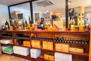 Boutique de l'Abbaye de Lérins présentant bouteilles de vin, liqueurs et caisses de bois sur des étagères