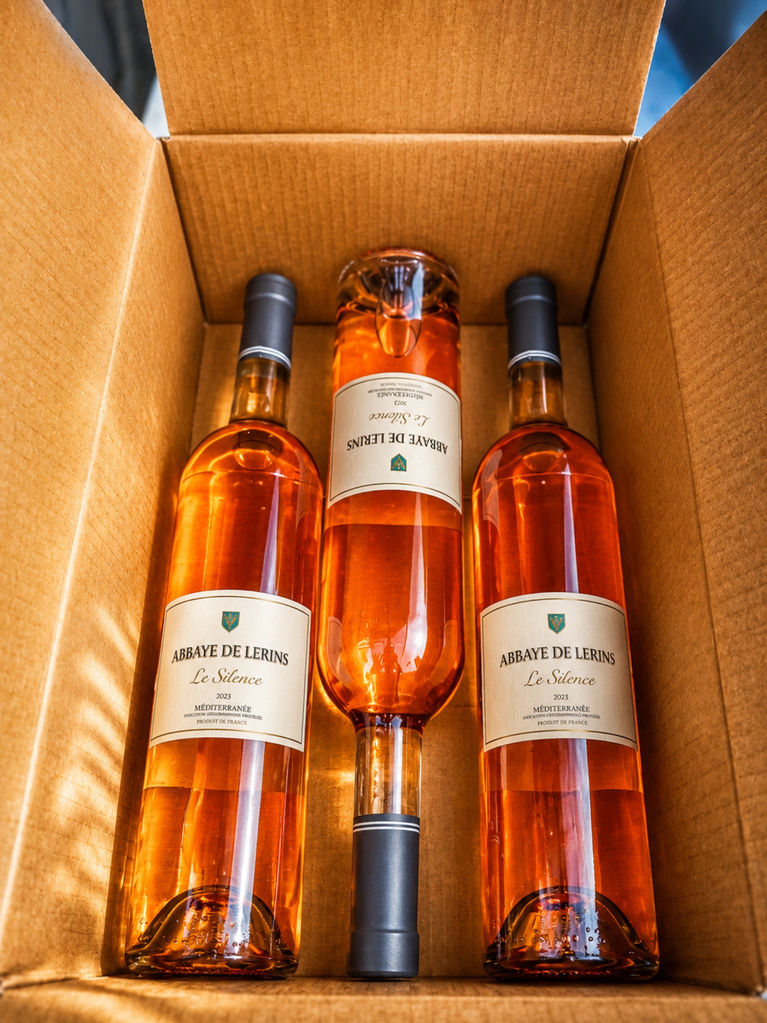 Trois bouteilles de rosé Le Silence de l'Abbaye de Lérins rangées dans un carton d'expédition