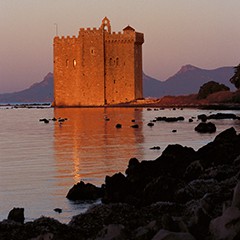 Monastère fortifié de l'Abbaye de Lérins sur l'île Saint-Honorat se reflétant dans la mer au coucher du soleil